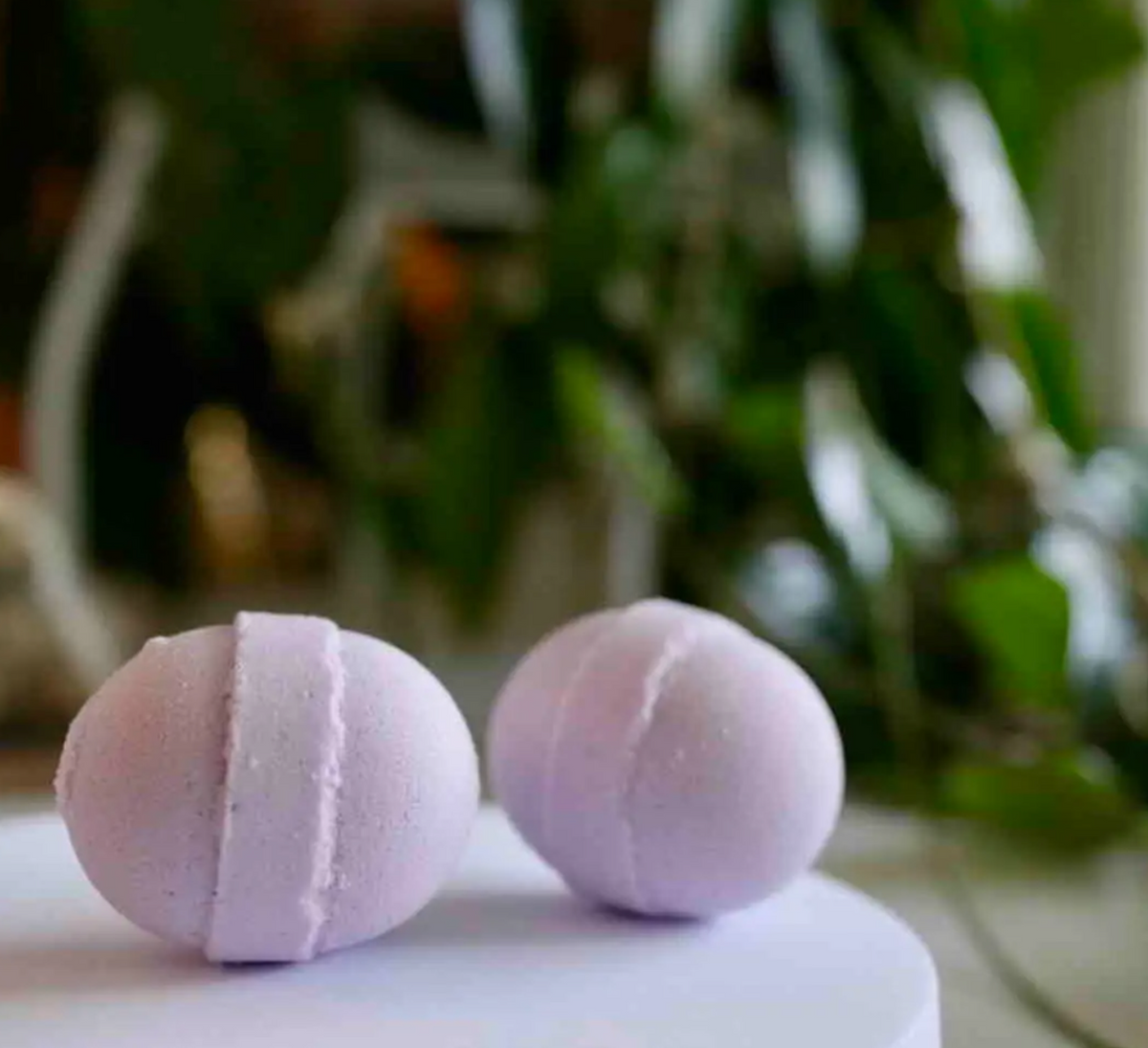 Two pink mini bath bombs on a white surface, aromatic bath fizzers for relaxing spa baths, skincare, self-care, aromatherapy and gifts