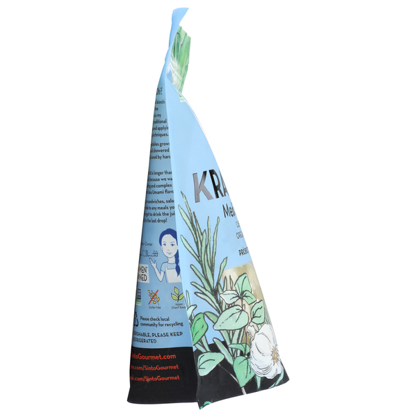Side view of Sinto Gourmet Kraut-Chi Mediterranean fermented sauerkraut and kimchi probiotic blend in a light blue stand-up pouch with botanical herb illustrations on a white background.