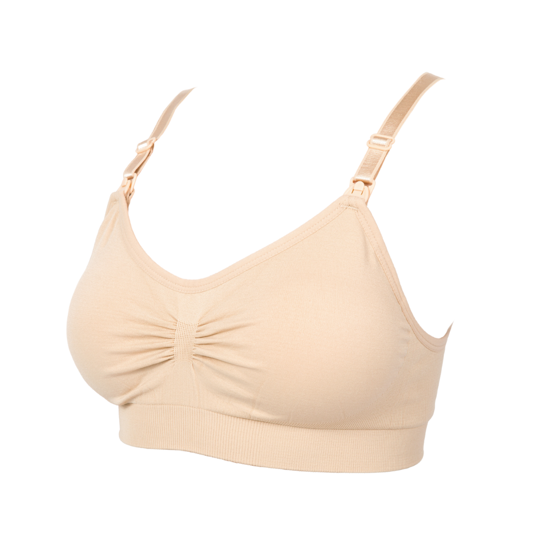 Beige seamless nursing bra with adjustable shoulder straps, a ruched front, removable clip-down cups for breastfeeding access, and a wide supportive underband on a white background.