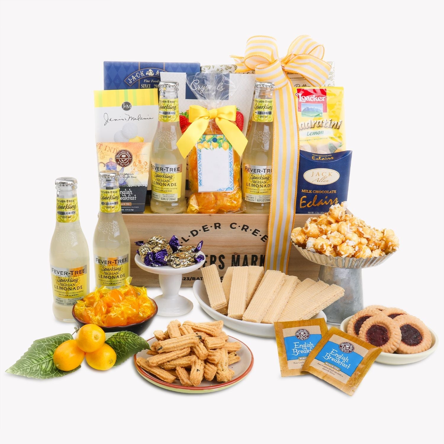 Sunshine is for Lemonade gourmet gift basket featuring non-alcoholic Fever-Tree Sparkling Lemonade, English Breakfast Tea, lemon cookies, butter cookies, caramel popcorn, gourmet snacks, chocolates, and citrus-themed treats beautifully arranged in a wooden crate with a yellow ribbon on a white background.