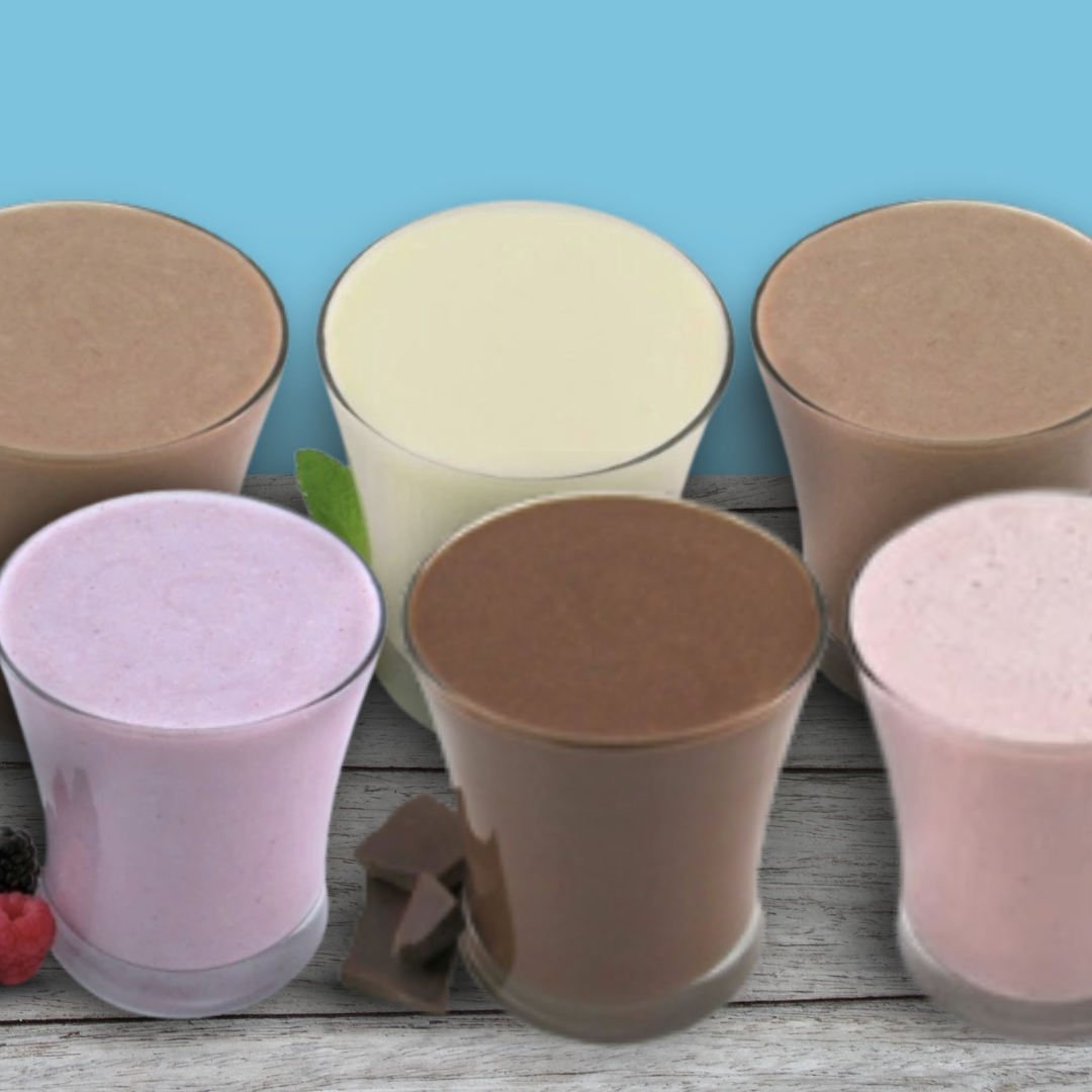 Six glasses of different colored shakes on a wooden surface with a blue background