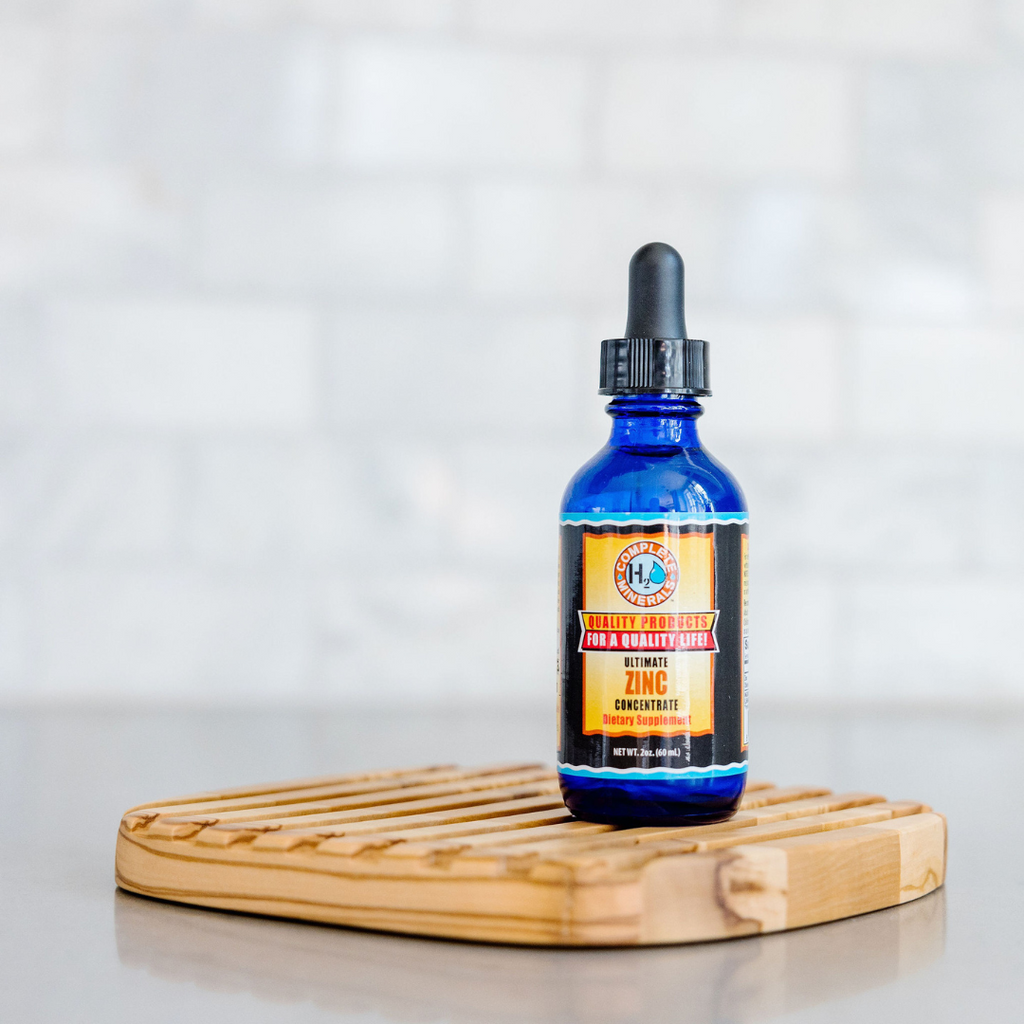 Blue bottle with dropper on a wooden coaster against a light background