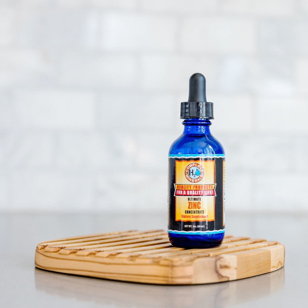 Blue bottle with dropper on a wooden coaster against a light background
