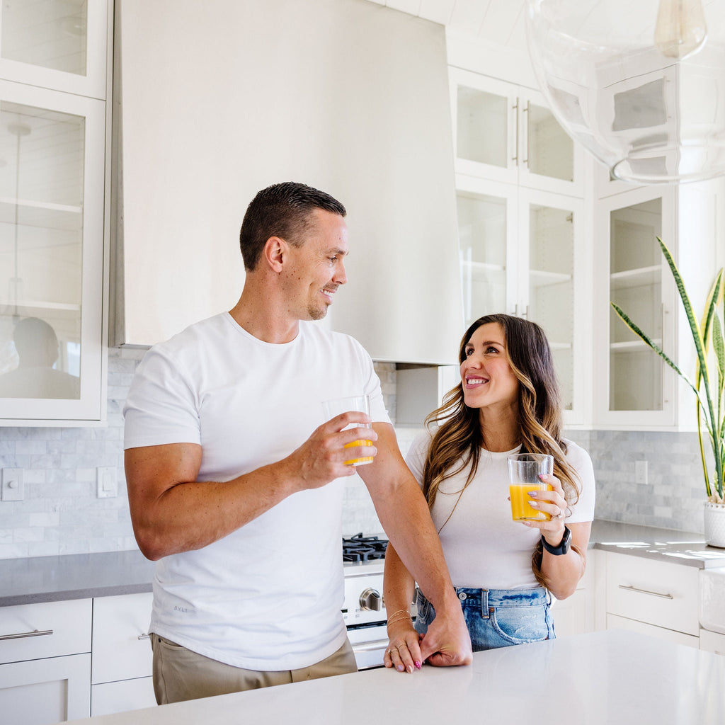 Man and woman in a modern kitchen holding drinks