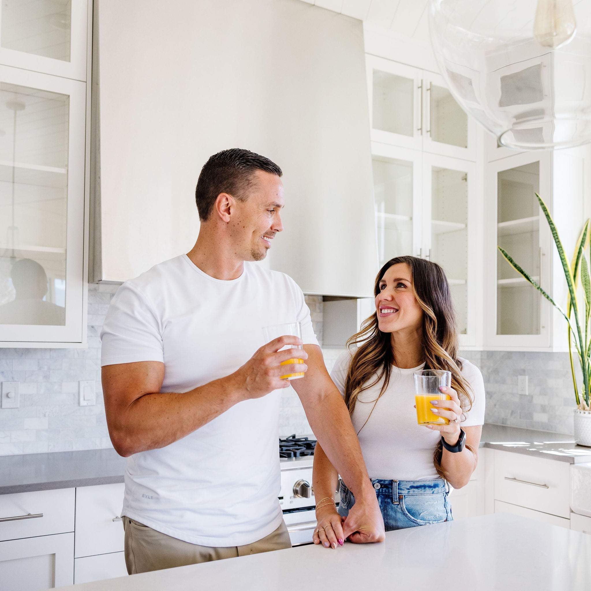 Man and woman in a modern kitchen holding drinks