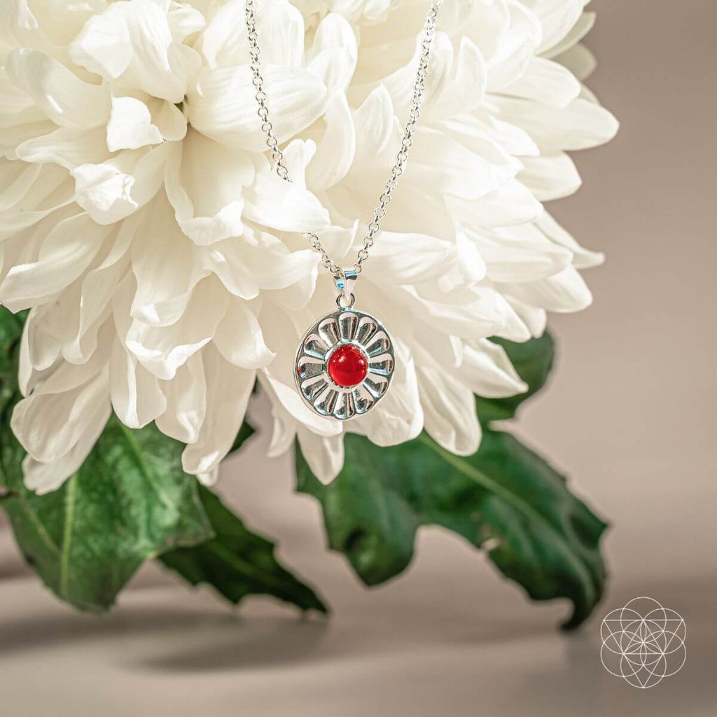 Silver necklace with a red pendant on a white flower. Necklaces with carnelian pendant.