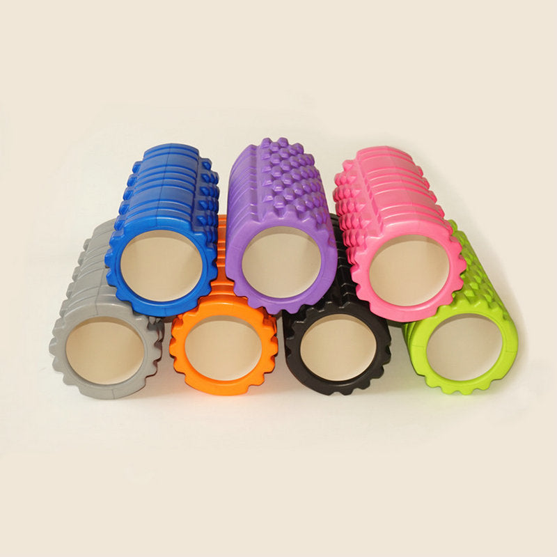 Set of colorful foam rollers on a beige background