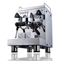 Stainless steel semi-automatic espresso machine with dual steam wands and two white espresso cups on the warming tray, displayed on a white background.
