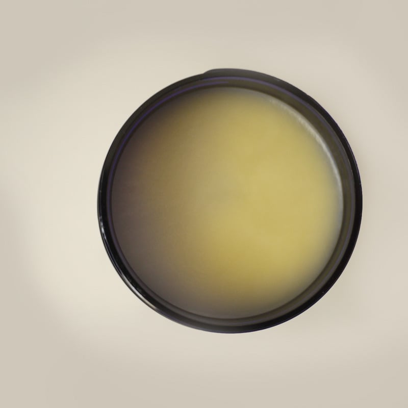 Round camera lens filter with gradient effect on a beige background. Infused Organic Coconut Oil with Calendula & Red Clover – 100% Organic Moisturizing Body Oil