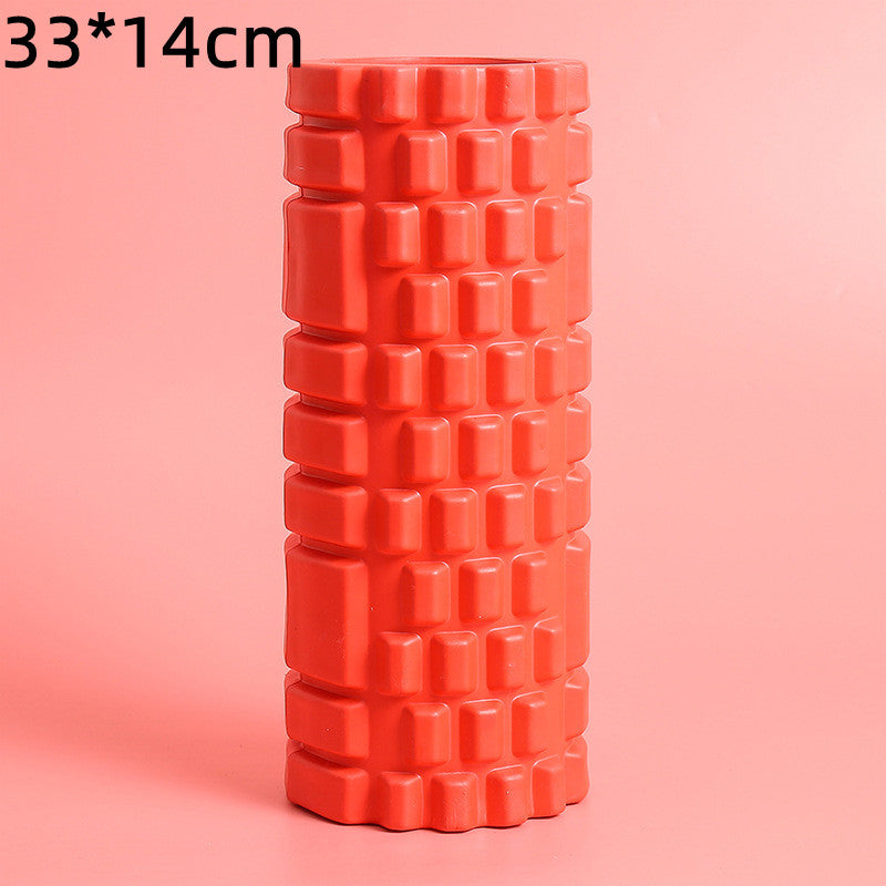 Red foam roller with textured surface on a pink background