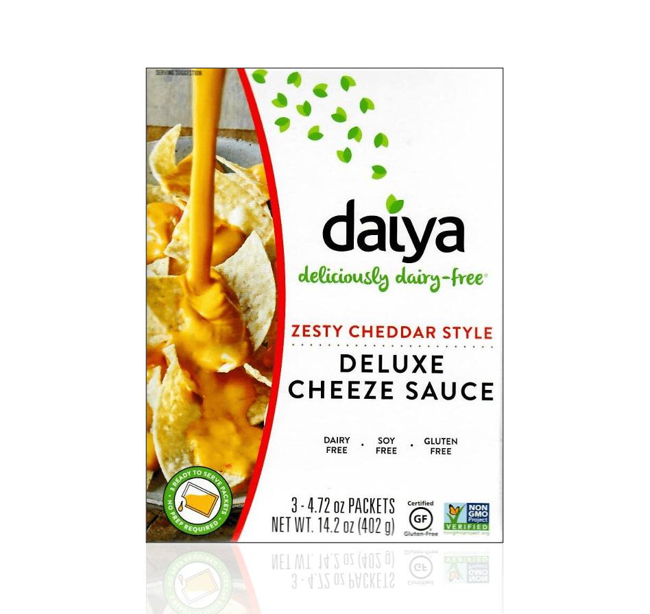 Daiya Zesty Cheddar Style Deluxe Cheeze Sauce packaging featuring dairy-free vegan cheddar-style cheese sauce being poured over tortilla chips. Gluten-free, soy-free, Non-GMO Project Verified, ready-to-serve cheese sauce in 3 convenient pouches.