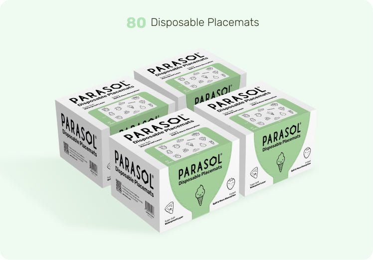 Multiple boxes of Parasol disposable placemats on a light green background. Baby placemats.