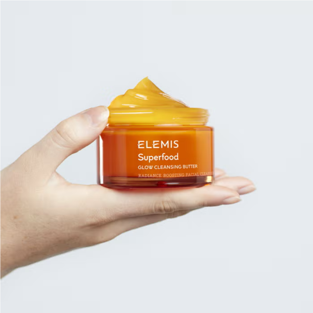 Hand holding ELEMIS Superfood Glow Cleansing Butter 90ml, a radiant 3-in-1 facial cleanser and makeup remover for soft, hydrated, glowing skin.