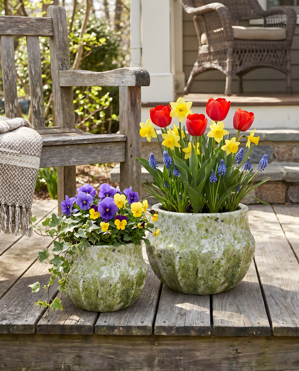 Two flower pots with colorful flowers on a wooden deck
