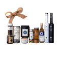 Collection of gourmet food and beverage items on a wooden board with 'The Epicurean Trader' box in the background.
