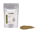 A silver stand-up pouch of isshiki Japanese Roasted Green Tea (Hojicha) shown next to a small pile of the brown tea powder on a white background.