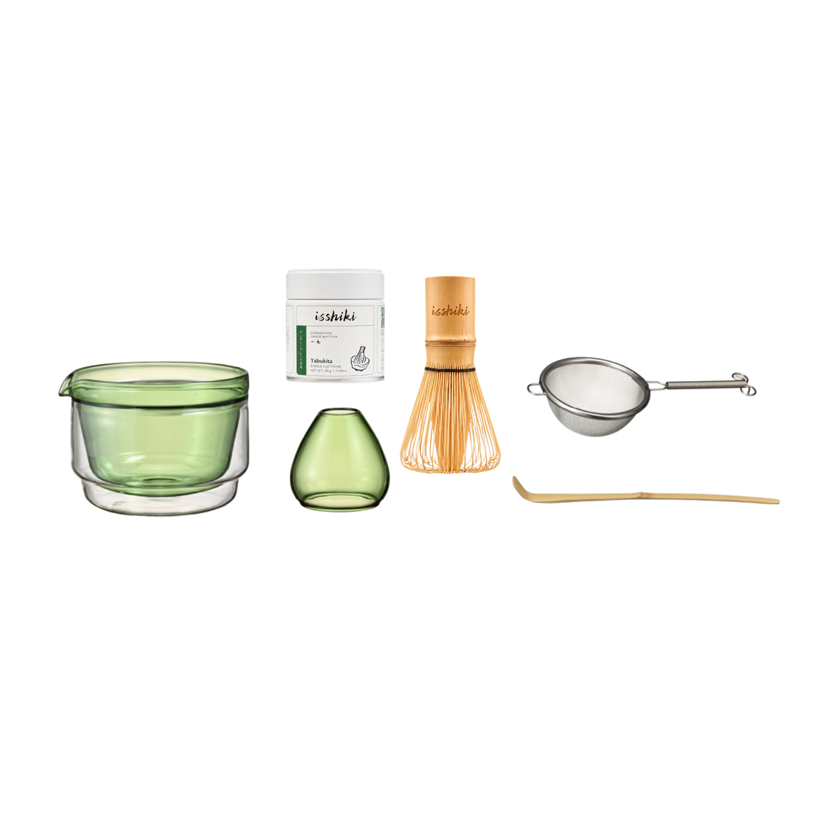 A set of green tea preparation accessories arranged on a white background, including a double-walled green glass bowl, a small green glass vase, a bamboo whisk, a metal strainer, and a bamboo scoop. A small white box labeled 'iZakura' is also shown.
