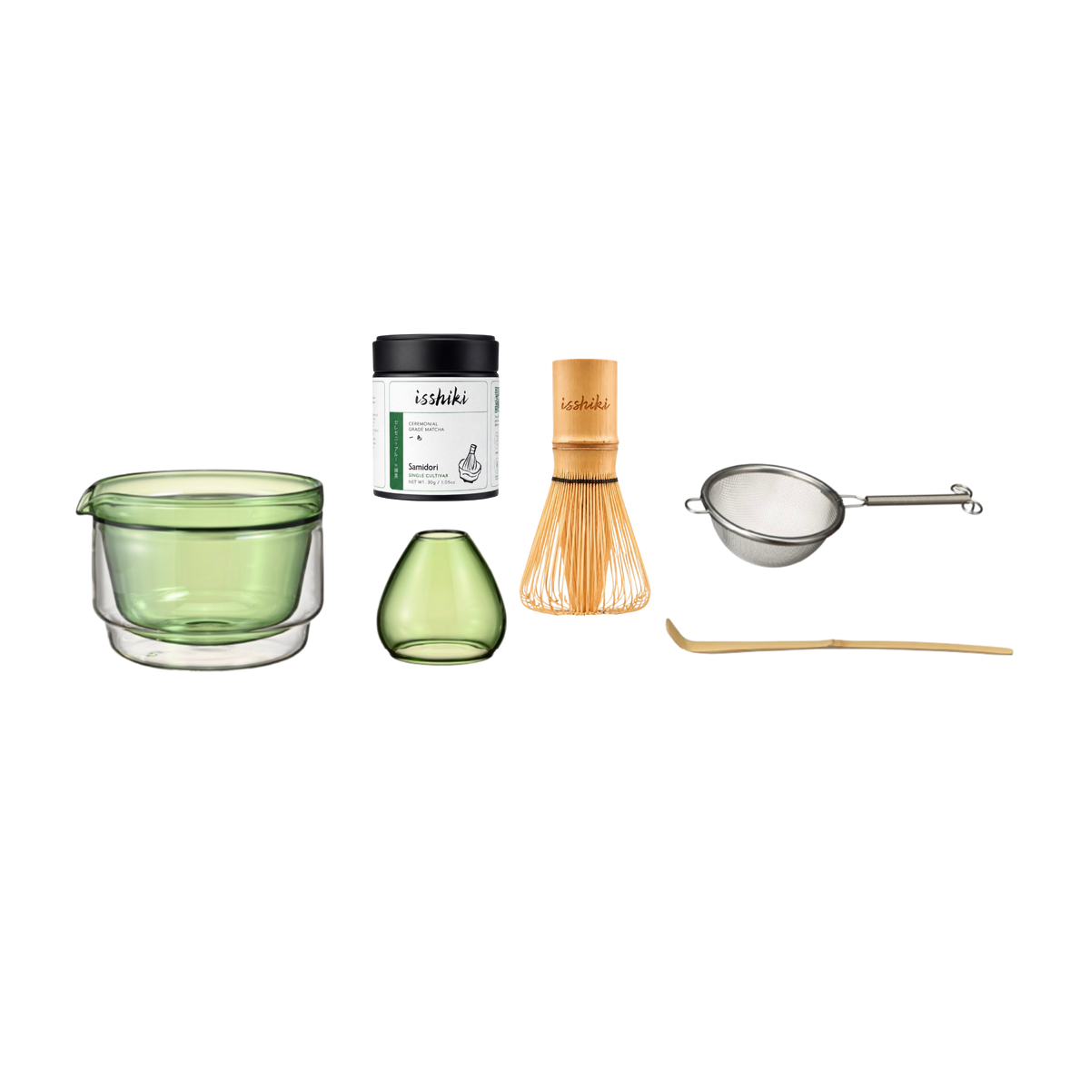 Set of tea-making tools including a green glass cup, small green vase, black container, wooden whisk, metal sieve, and wooden spoon on a white background.