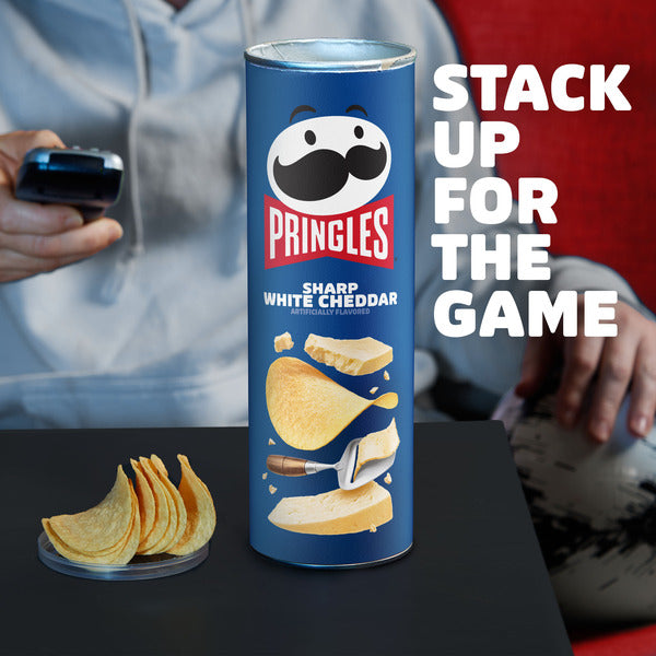 Pringles Sharp White Cheddar can with people in the background