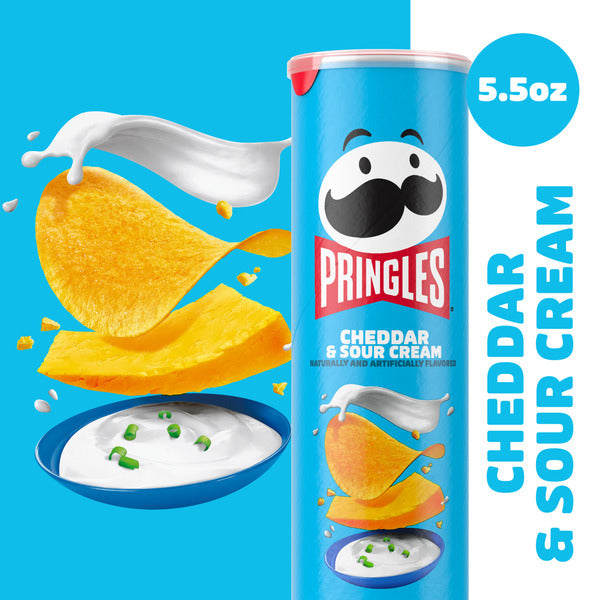 Pringles Cheddar & Sour Cream potato chip can with chips and dip on a blue background