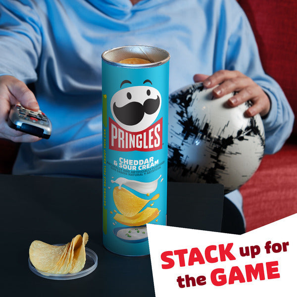 Pringles can with a person holding a football and remote control, text 'Stack up for the Game' displayed.