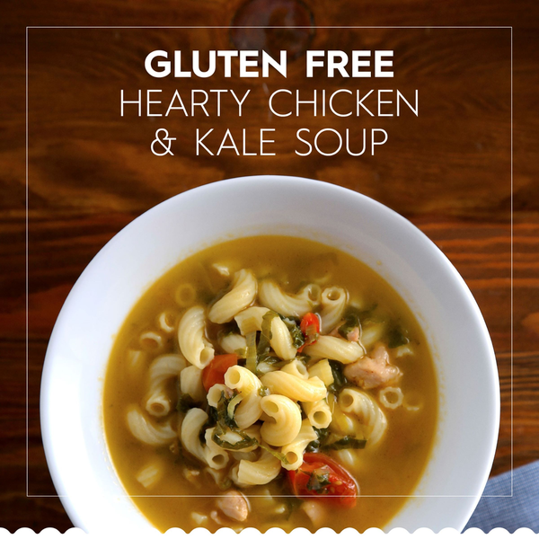 Gluten-free hearty chicken and kale soup in a white bowl on a wooden table. Barilla Gluten Free Elbows Pasta