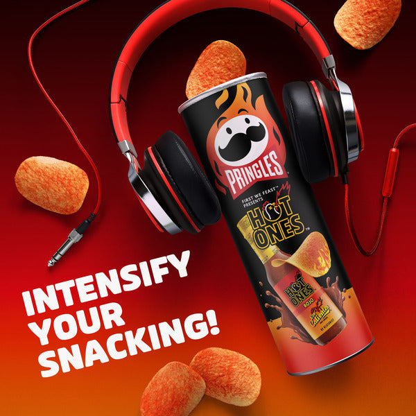 Pringles Hot Ones can with headphones and snacks on a red background