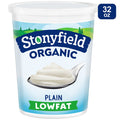 Stonyfield Organic plain lowfat yogurt container with a spoonful of yogurt on a white background
