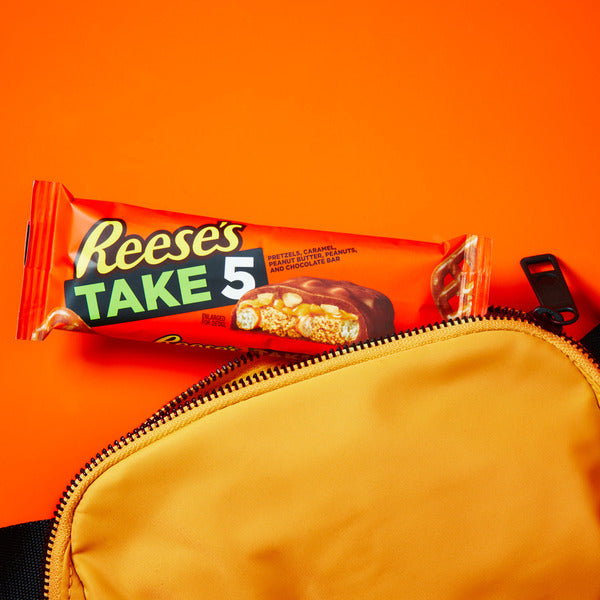 Reese's Take 5 candy bar package on an orange background