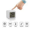 Digital clock with a hand pointing at it, displaying time and date on a white background.