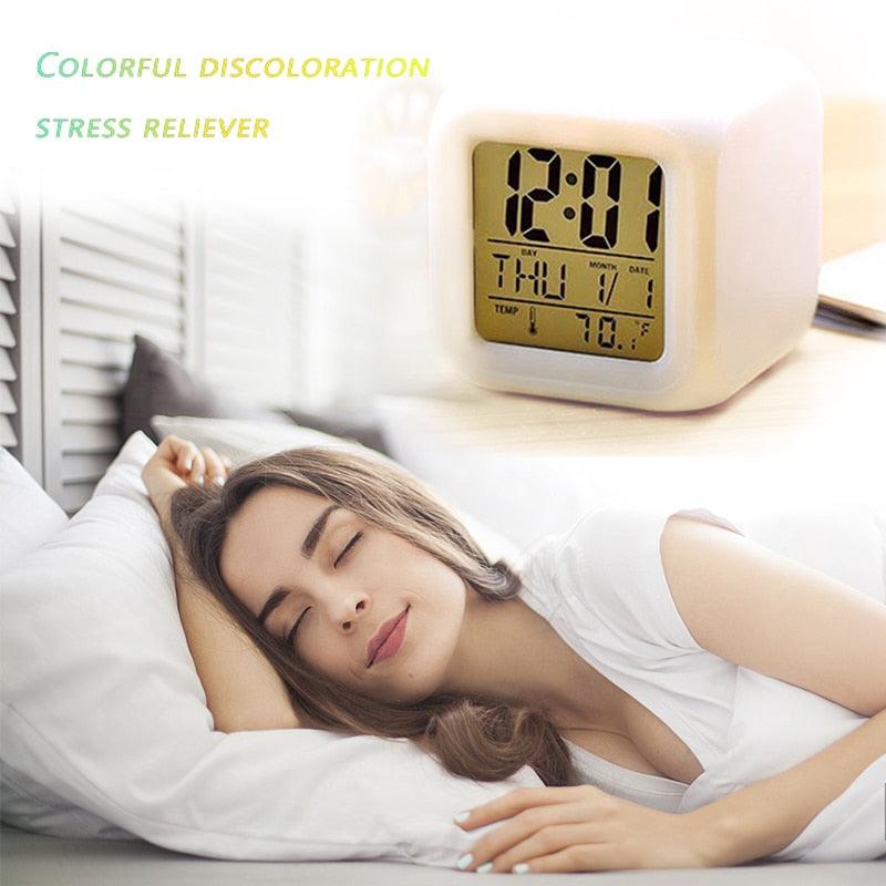 Woman sleeping in bed with a digital clock showing 12:01 on a nightstand.