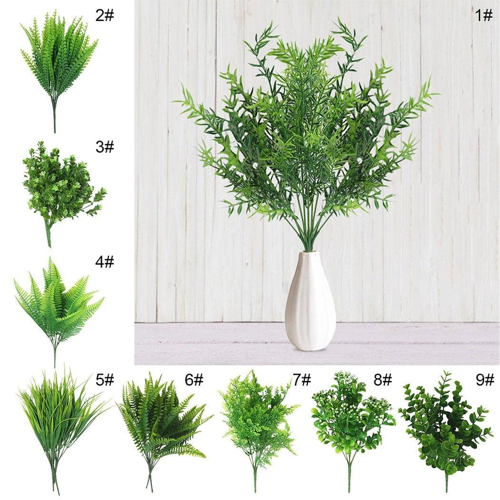 Set of artificial plants with a white vase on a light wooden background