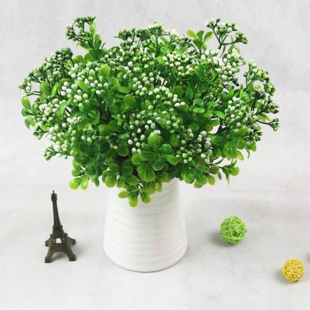 Bouquet of greenery in a white vase on a light gray background