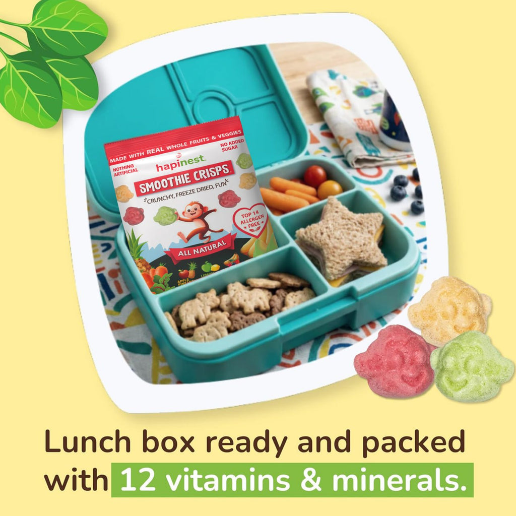 A turquoise divided lunch box shown open with snacks inside, including a packaged snack box labeled 'happiest Smoothie Crisps' and star-shaped crackers. The scene is styled on a pale yellow background with decorative leaves, a cloth, fruit, and gummy candies, plus text reading 'Lunch box ready and packed with 12 vitamins & minerals. Tree Nut-Free, Peanut-Free, Egg-Free, Dairy-Free, Wheat-Free, Fish-Free, Sesame-Free, Celery-Free, Lupin-Free, Soy-Free, Shell-Fish Free, Gluten-Free, Mustard-Free
