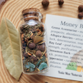 Money Bowl spell jar with green aventurine, bay leaf, allspice berries, cinnamon bark, peppermint and dried herbs for prosperity and abundance.