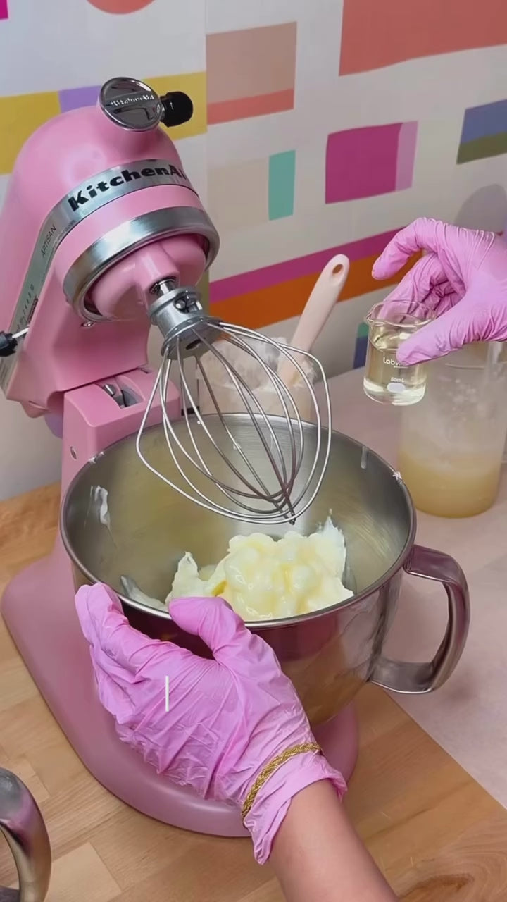 Aminnah Birthday Cake whipped body butter being handcrafted with natural ingredients in a pink stand mixer, clean beauty skincare made with organic shea butter, vegan, cruelty free, paraben free, gluten free, recyclable packaging, female owned brand, luxurious body care manufacturing process.