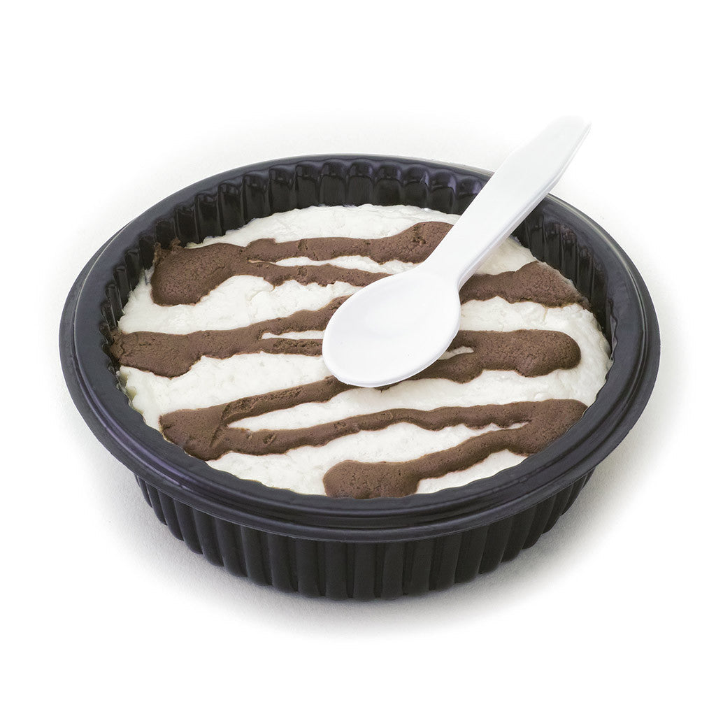 Low-carb sugar-free cheesecake dessert topped with rich chocolate drizzle in a black dessert cup with a white plastic spoon, isolated on a white background.