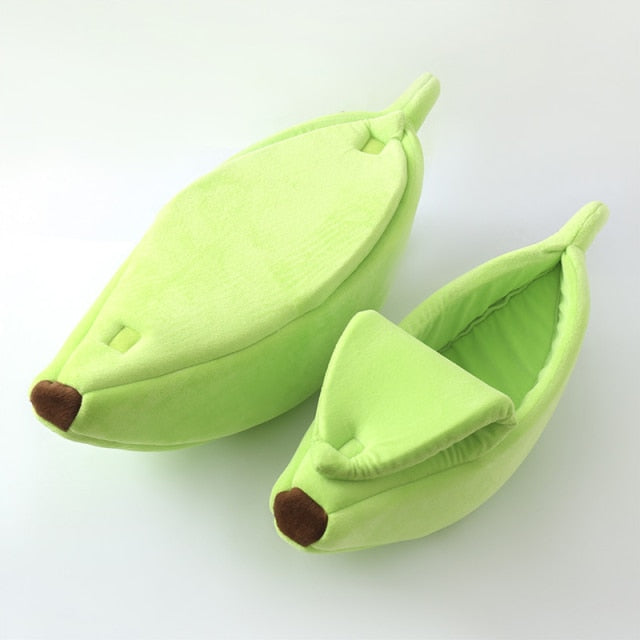 Green banana-shaped plush pet bed with a cozy cave design for cats, kittens, puppies, and small dogs on a white background.