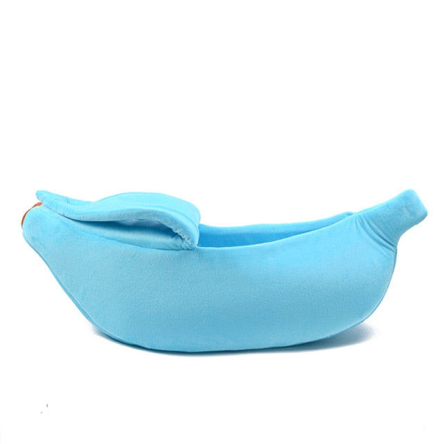 Blue banana-shaped plush pet bed with a soft cave design for cats, kittens, puppies, and small dogs on a white background.