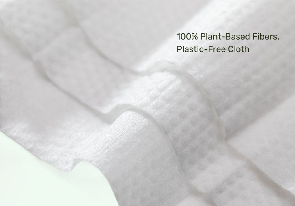 Close-up of Parasol baby wipe made from 100% plant-based, plastic-free fibers with embossed texture and overlay text reading "100% Plant-Based Fibers. Plastic-Free Cloth."