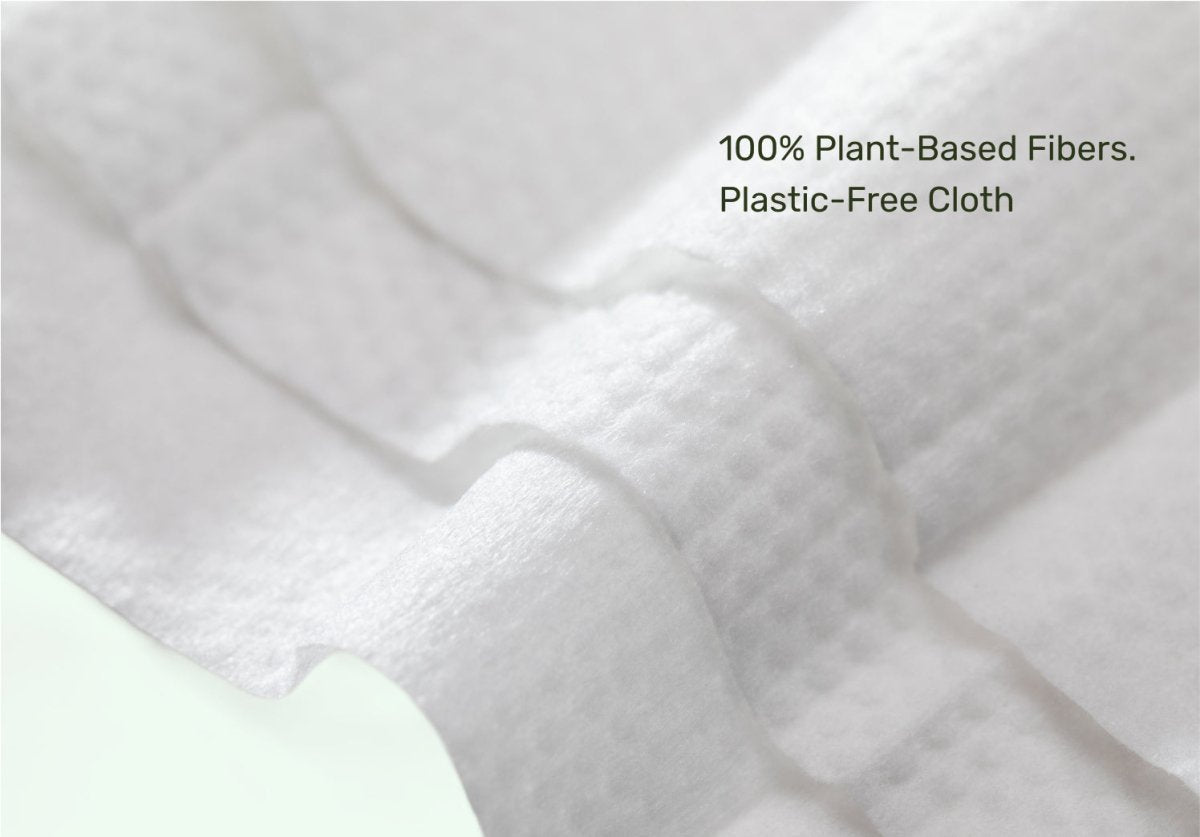 Close-up of Parasol baby wipe made from 100% plant-based, plastic-free fibers with embossed texture and overlay text reading "100% Plant-Based Fibers. Plastic-Free Cloth."