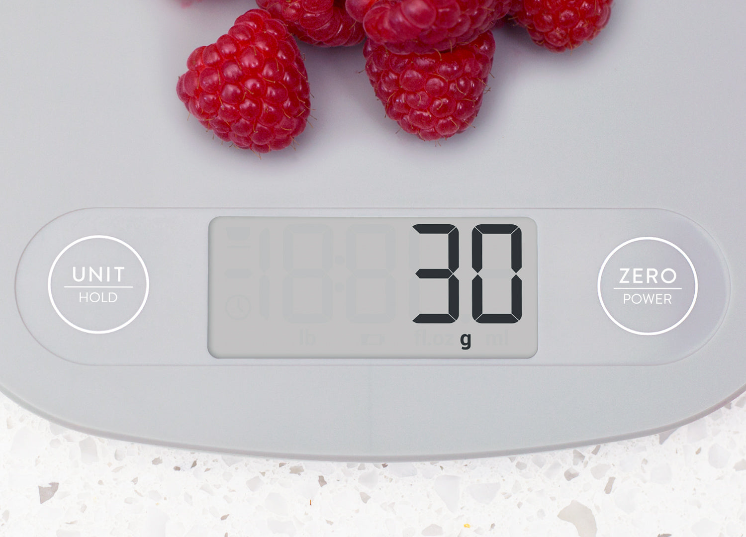 Digital kitchen scale with raspberries on a white background