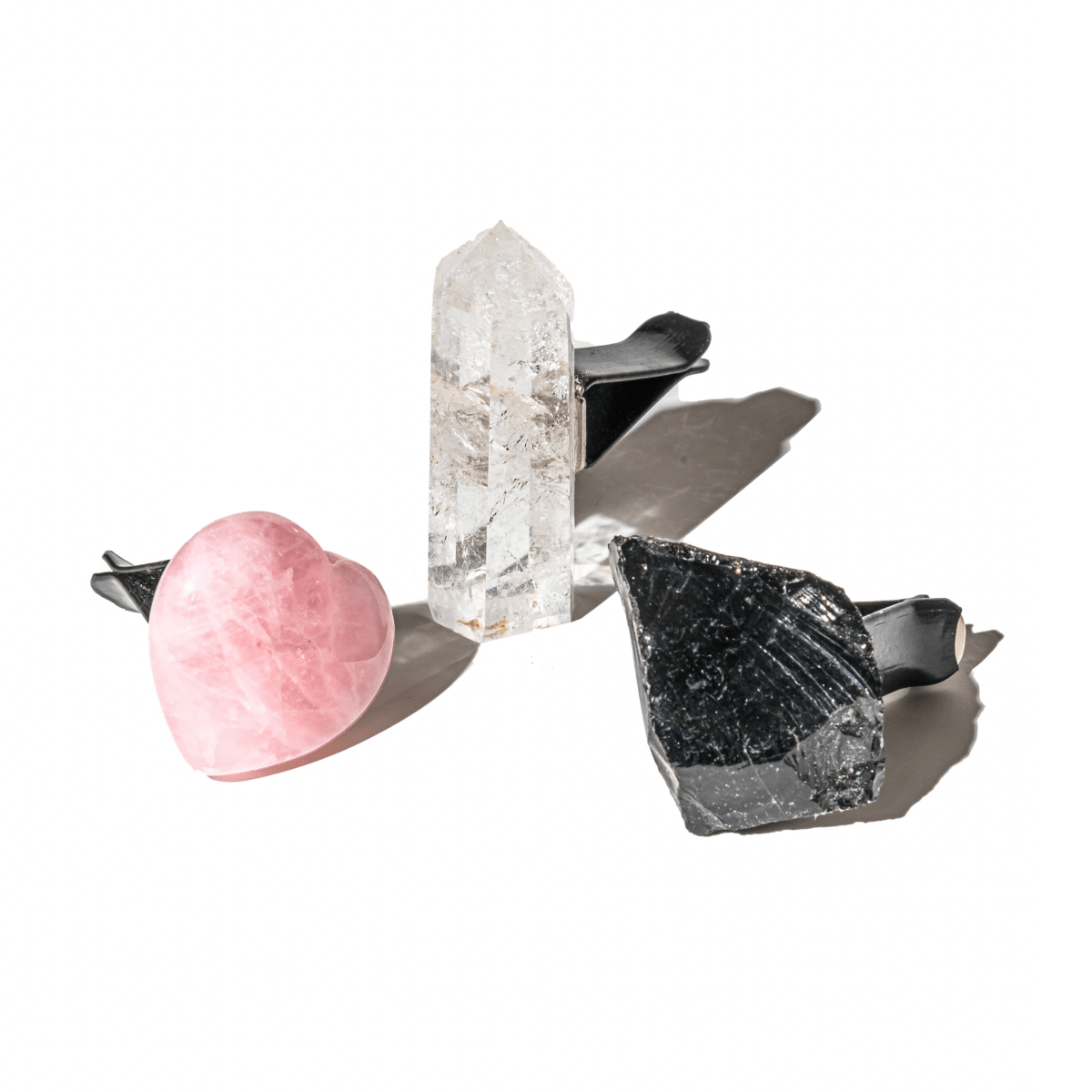 Three crystals on a white background: a pink crystal, a clear crystal, and a black crystal. Spiritual GPS Guardian Car Vent Crystal Clip Kit | Protection Crystals for Safe Travel & Positive Energy