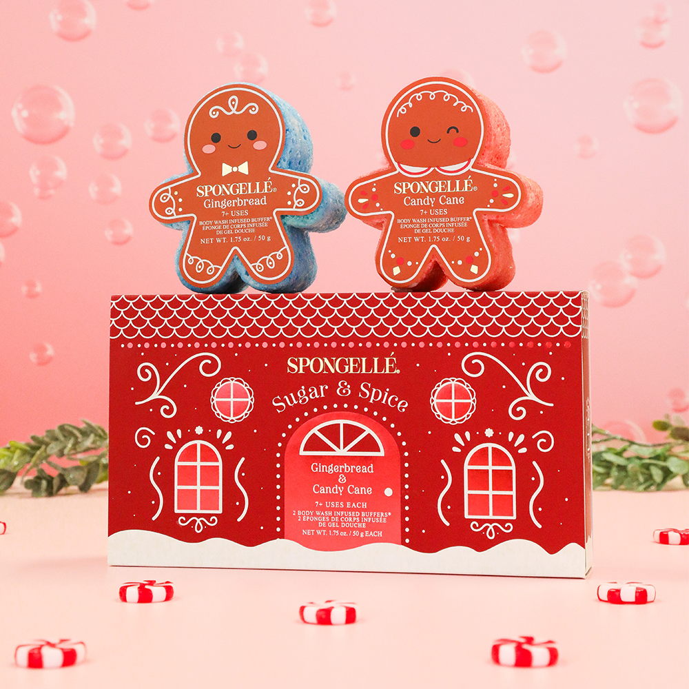 Spongellé Sugar & Spice Holiday Gingerbread Gift Set with Gingerbread and Candy Cane body wash infused buffers, exfoliating bath sponges, festive Christmas self-care, holiday spa gift for women, stocking stuffer, body care gift set on pink holiday background.