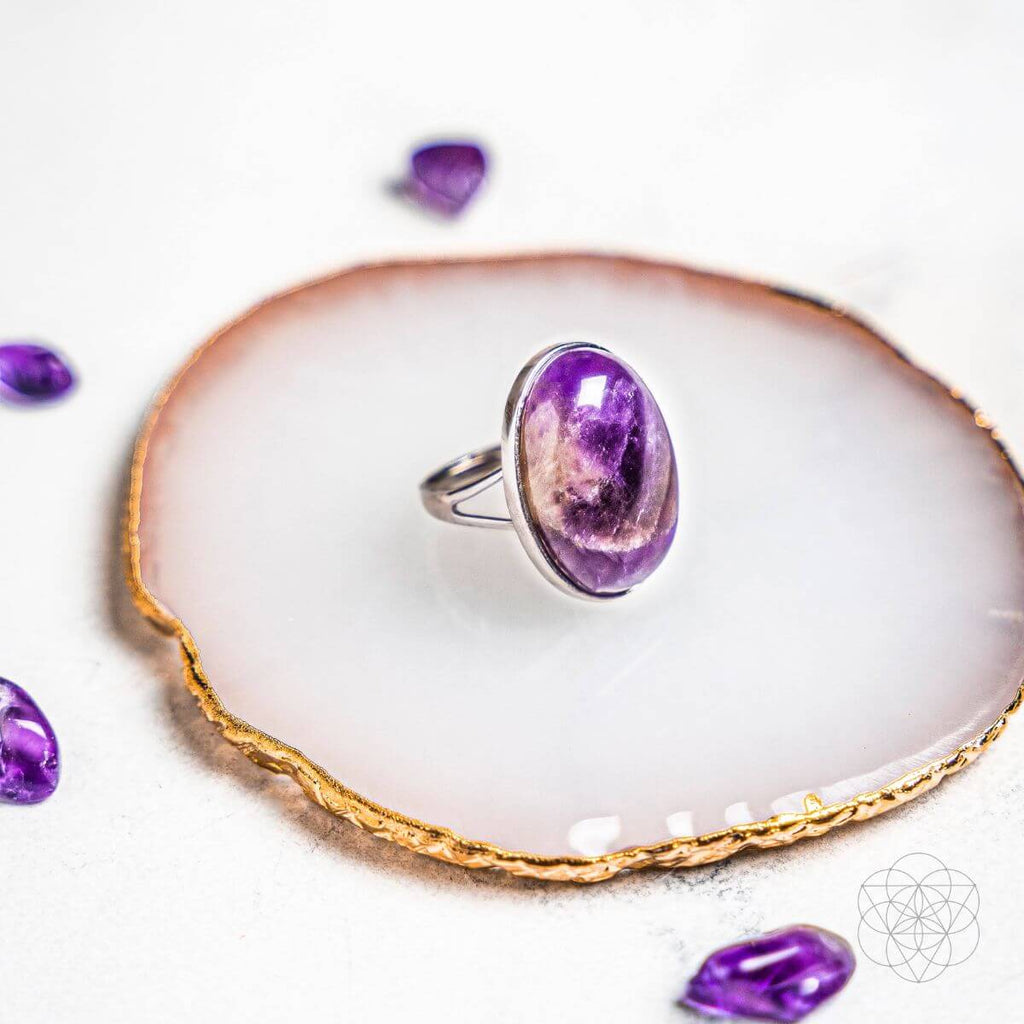 Purple gemstone ring on a white dish with gold rim. The Visualization Ring: Brass, Platinum and Amethyst