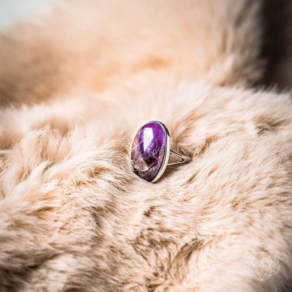 Ring with a purple gemstone on a fur surface. The Visualization Ring: Brass, Platinum and Amethyst