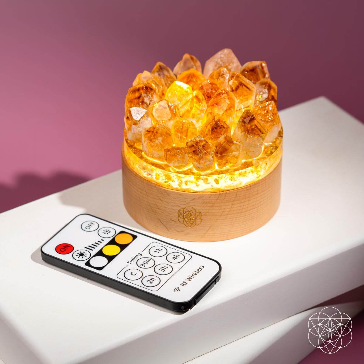Decorative lamp with crystal-like design and remote control on a white surface with a purple background. Turn My Life to Gold - Midas Citrine Lamp