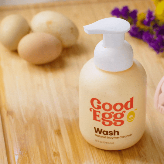 Natural enzyme egg cleanser demonstration showing a dirty fresh egg being cleaned with the GoodEgg Wash foaming brush. The food-grade, 99% organic enzyme formula lifts away mud and organic debris without penetrating the eggshell, making it ideal for cleaning fresh chicken, duck, and other poultry eggs before use.