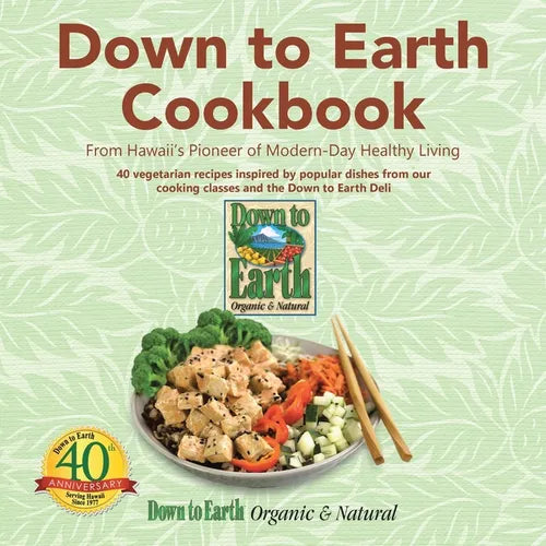 Down to Earth Cookbook book cover featuring a healthy vegetarian meal with tofu, broccoli, and vegetables served with chopsticks on a light green leaf-patterned background. Paperback cookbook with 40 vegetarian recipes inspired by Hawaii's Down to Earth Organic & Natural, celebrating modern healthy living and the store's 40th anniversary.